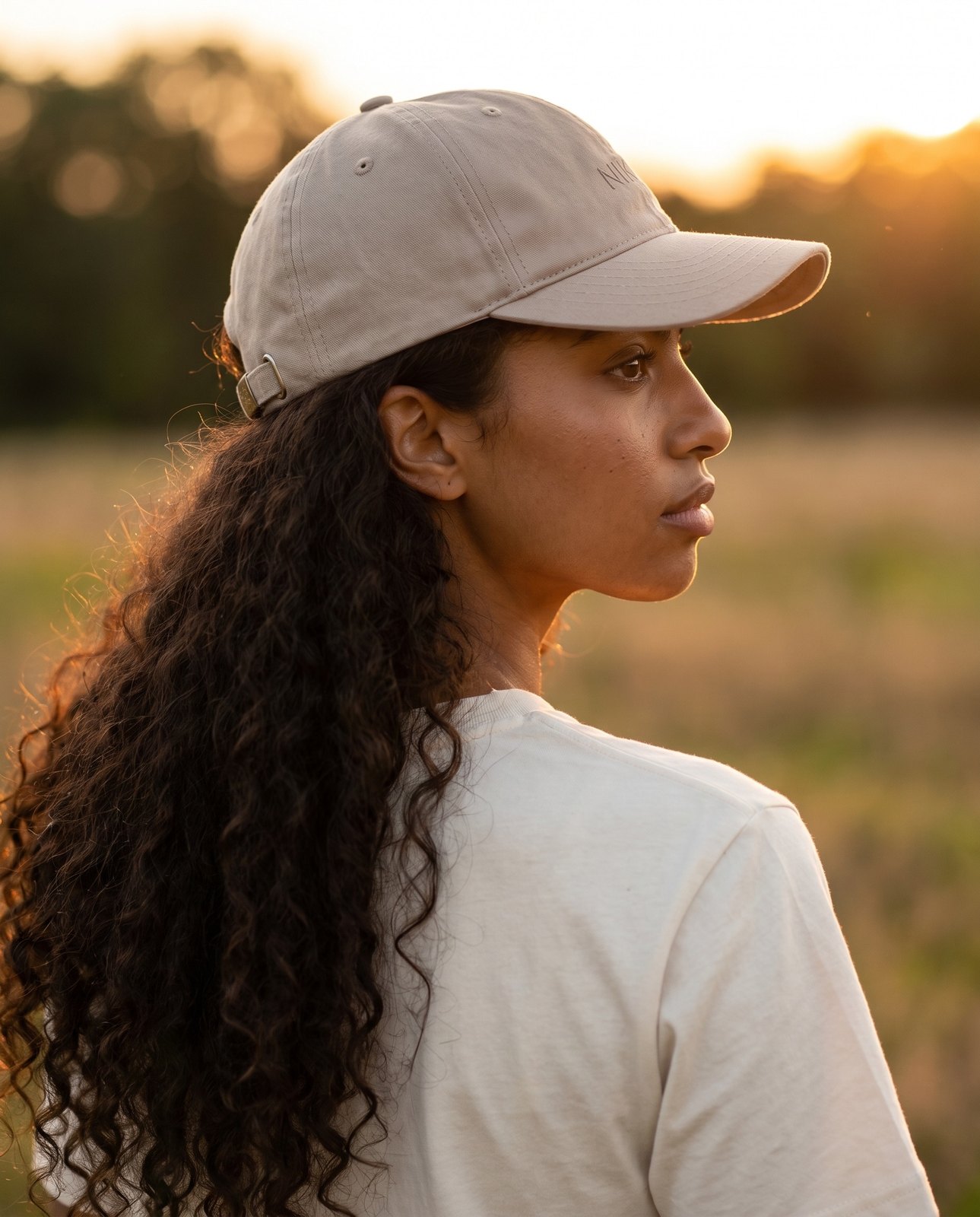 NIKIN Cap beige — Seitenprofil einer Frau zur goldenen Stunde